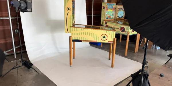 A pinball machine photography setup with lights and reflective background