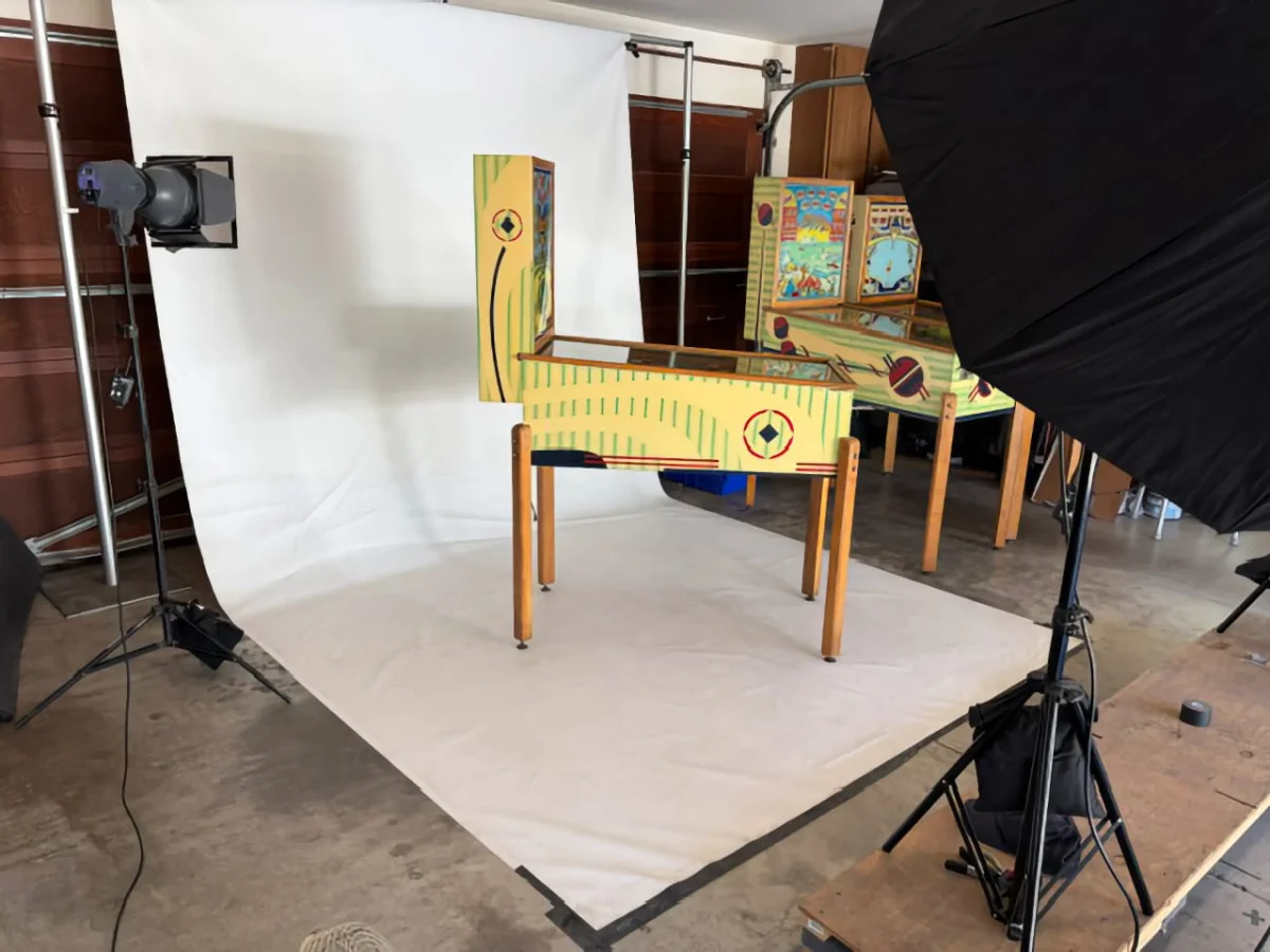 A pinball machine photography setup with lights and reflective background